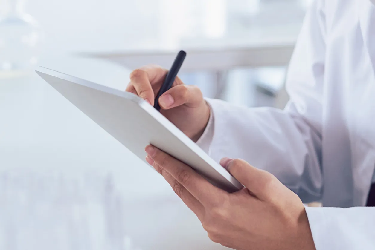 Person writing on a tablet.